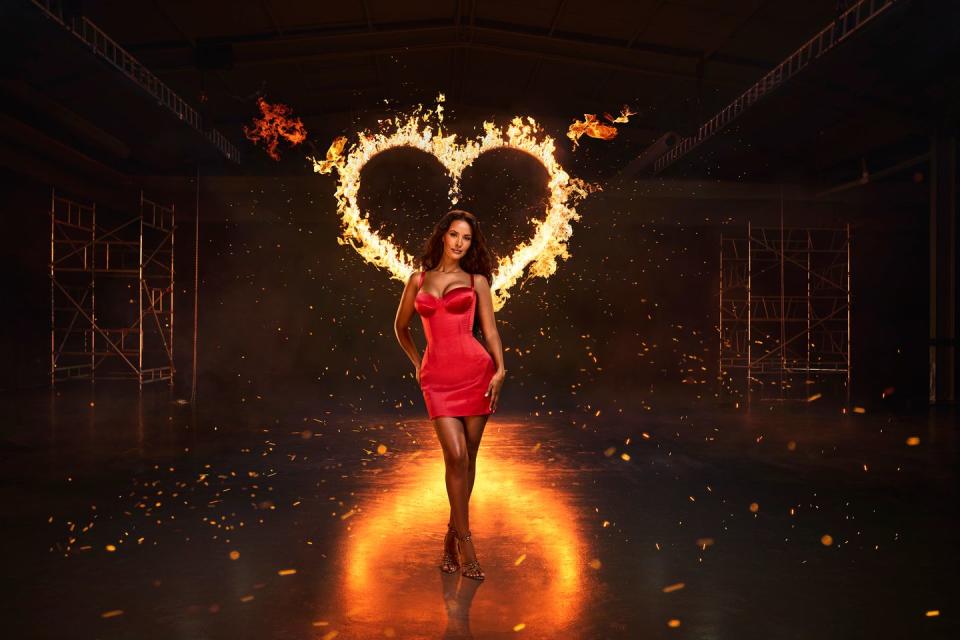 maya jama wearing a red dress in front of a flaming heart, love island season 11