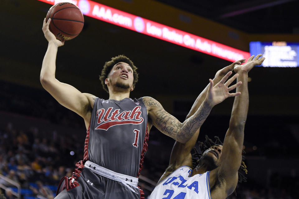 Utah forward Timmy Allen, left, goes up to shoot while UCLA forward Jalen Hill defends during the second half of an NCAA college basketball game in Los Angeles, Sunday, Feb. 2, 2020. (AP Photo/Kelvin Kuo)