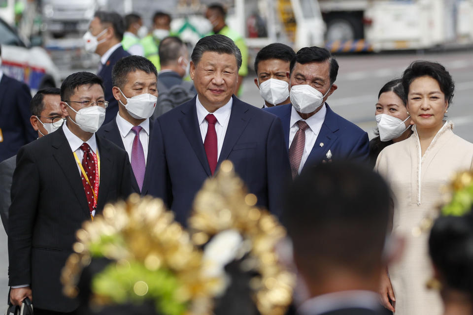 Chinese President Xi Jinping, center, walks with his wive Peng Liyuan, right, upon arrival at Ngurah Rai International Airport ahead of the G20 Summit in Bali, Indonesia, Monday, Nov. 14, 2022. (Ajeng Dinar Ulfiana/Pool Photo via AP)