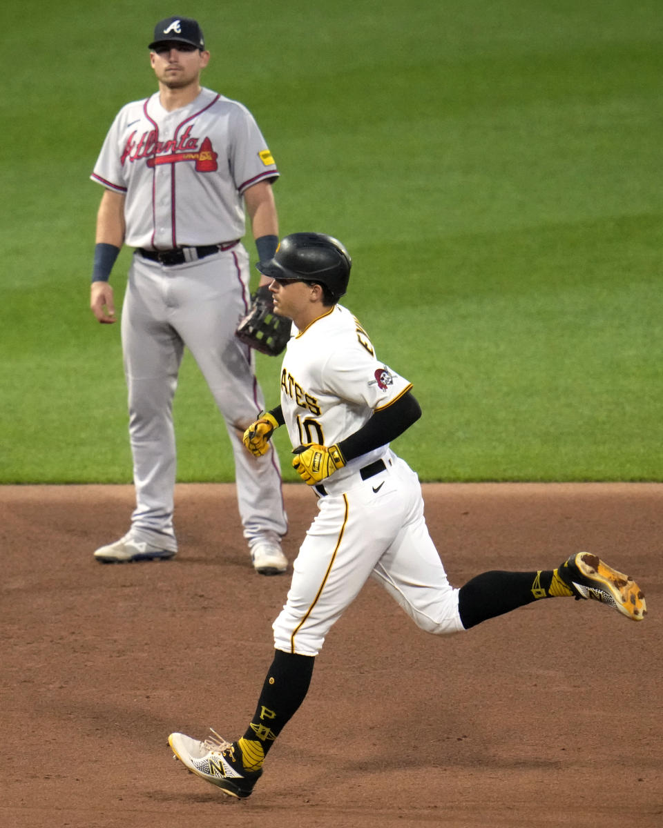 Pittsburgh Pirates' Bryan Reynolds runs the bases past Atlanta Braves third baseman Austin Riley after hitting a solo home run during the fifth inning of a baseball game in Pittsburgh, Tuesday, Aug. 8, 2023. (AP Photo/Gene J. Puskar)