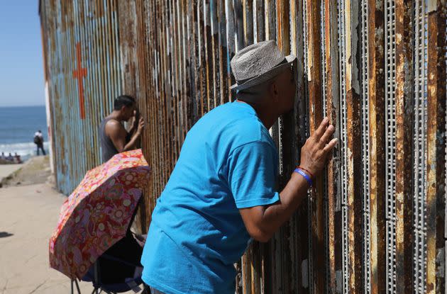 FILE - Carlos, who lived in Los Angeles 28 years undocumented before being deported to Mexico, kisses his wife through the meshed U.S.-Mexico border on September 25, 2016 in Tijuana, Mexico. (Photo: John Moore via Getty Images)