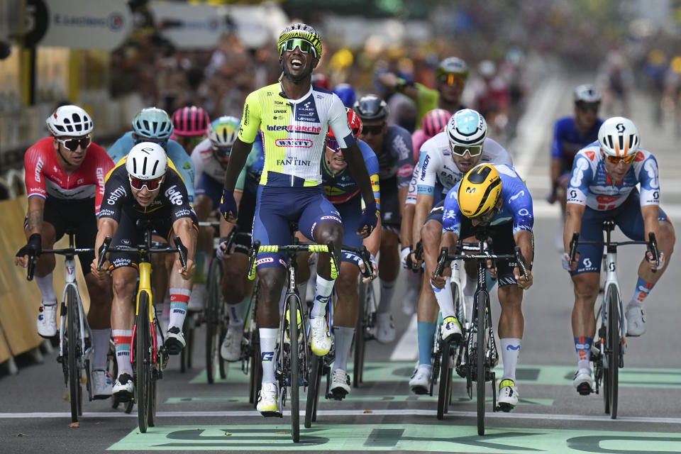 Eritrea's Biniam Girmay celebrates as he crosses the finish line ahead of Netherlands' Dylan Groenewegen, left, Belgium's Arnaud de Lie, second left, Colombia's Fernado Gavira, second right, ans Netherlands' Fabio Jakobsen, right, to win the third stage of the Tour de France cycling race over 230.8 kilometers (143.4 miles) with start in Piacenza and finish in Turin, Italy, Monday, July 1, 2024. (AP Photo/Daniel Cole)