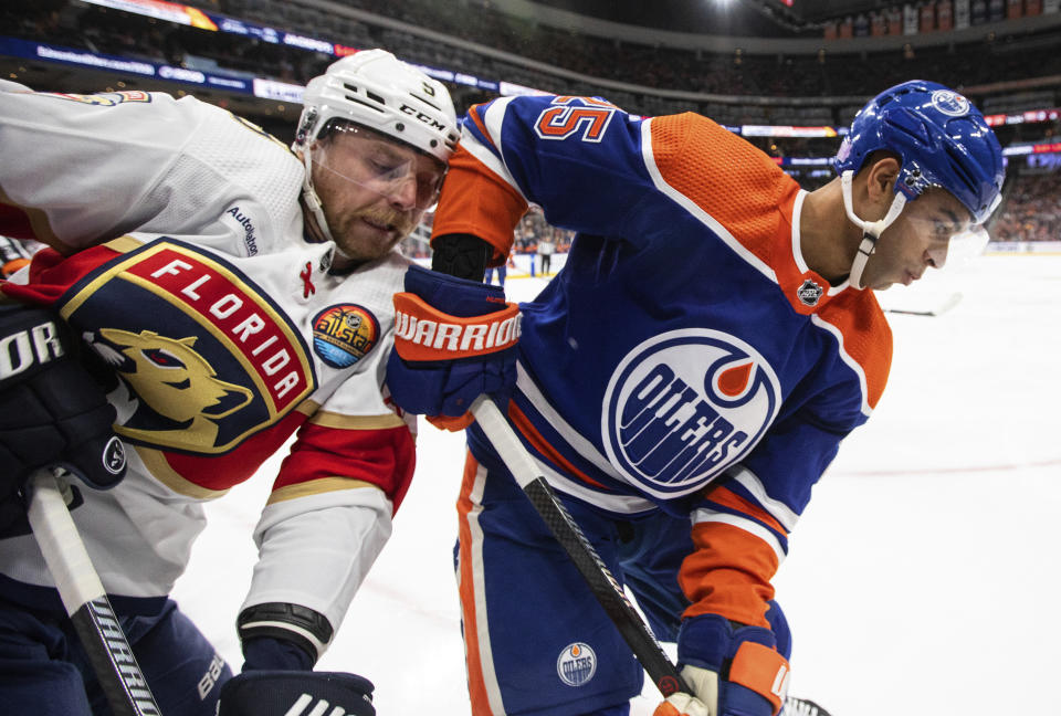 Florida Panthers' Sam Bennett (9) and Edmonton Oilers' Darnell Nurse (25) battle for the puck during first-period NHL hockey game action in Edmonton, Alberta, Monday, Nov. 28, 2022. (Jason Franson/The Canadian Press via AP)