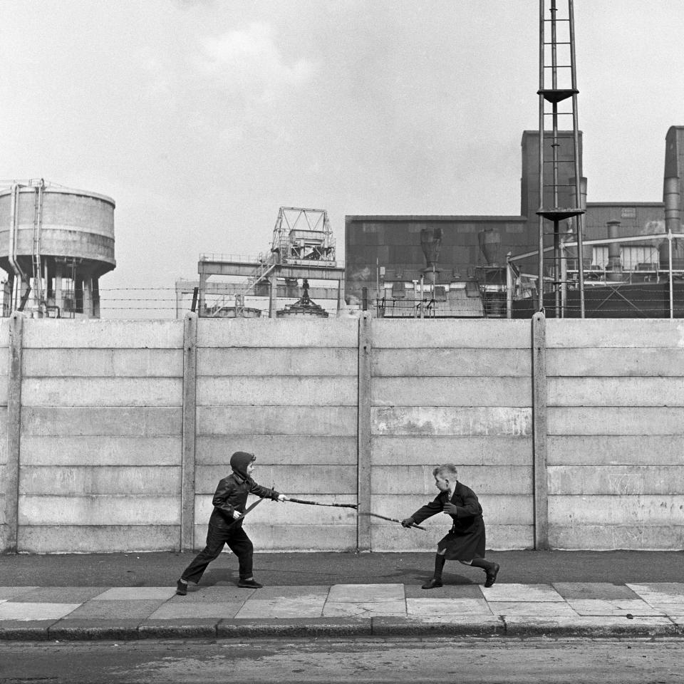 Two boys fighting with sticks in front of a concrete wall, London, UK, circa 1960. (Photo by Frederick Wilfred/Getty Images)  - Getty