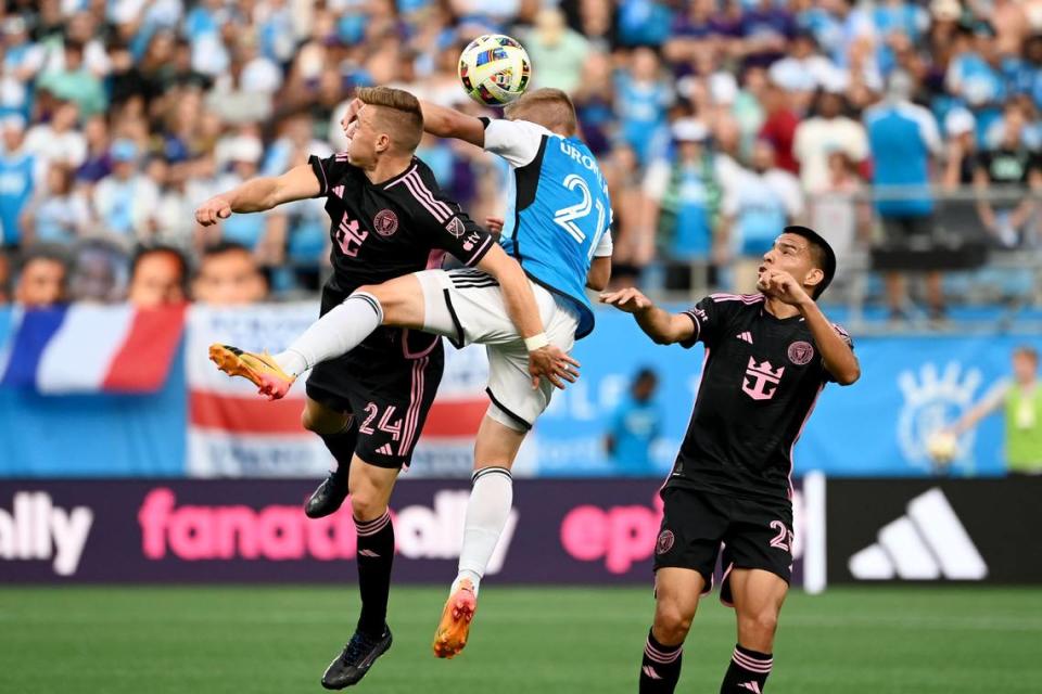 Jul 3, 2024; Charlotte, North Carolina, USA; Charlotte FC defender Jere Uronen (21) and Inter Miami CF midfielder Julian Gressel (24) jump to head the ball in the first half at Bank of America Stadium. Mandatory Credit: Bob Donnan-USA TODAY Sports