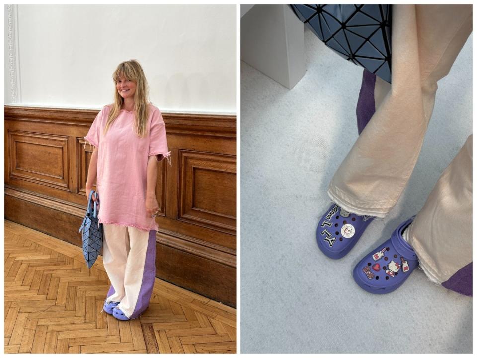 Trend forecaster Kelly Harrington wearing purple Crocs with sanrio charms and her name spelled out on one. She is wearing cream jeans, a pink oversized tshirt and a purple bag.