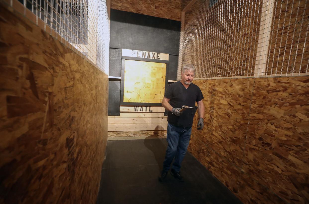 PenAxe's Greg Randall looks over his axe as he prepares to throw at Port Orchard's Town Square Mall on Wednesday, July 12, 2023.