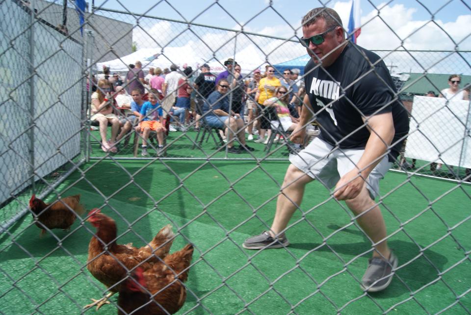 Allen Bexley chases three chickens as part of the Cajun Cup at the Bayou Terrebonne Boucherie, Saturday, March 25.