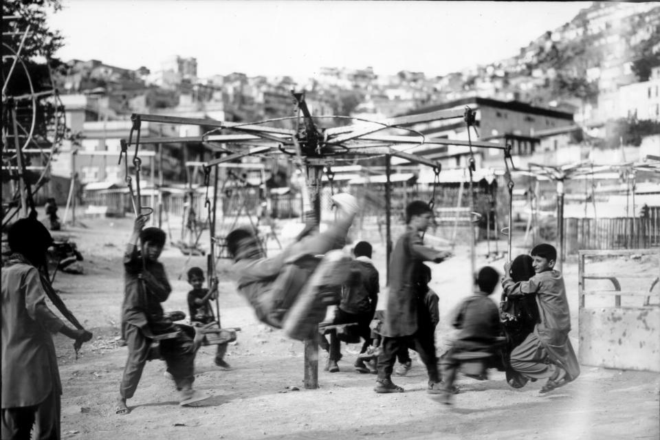 Children play on swings near the Kart-e Sakhy cemetery in Kabul, Afghanistan, Thursday, June 8, 2023. (AP Photo/Rodrigo Abd)