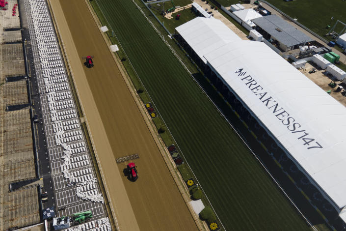 Tractors groom the final straightaway at Pimlico Race Course ahead of the 147th running of the Preakness Stakes horse race, Thursday, May 19, 2022, in Baltimore. (AP Photo/Julio Cortez)