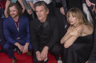 Producer Cory Pyke, left to right, director Ethan Hawke and Maya Hawke crouch on the ground for a group shot as they attend the premiere of "Wildcat," at the Royal Alexandra Theatre during the Toronto International Film Festival, Monday, Sept. 11, 2023, in Toronto. (Photo by Joel C Ryan/Invision/AP)
