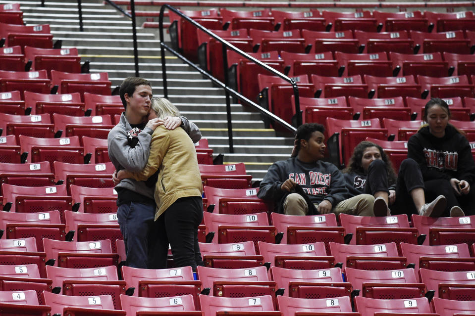 San Diego State fans hug in the stands after an NCAA college basketball game against UNLV, Saturday, Feb. 22, 2020, in San Diego. (AP Photo/Denis Poroy)