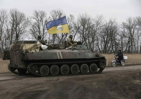 Members of the Ukrainian armed forces ride on an armoured personnel carrier near Artemivsk, eastern Ukraine, March 3, 2015. REUTERS/Gleb Garanich