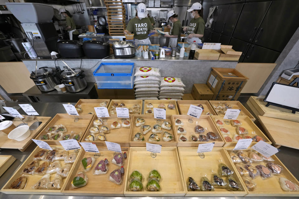 Workers make onigiri, rice balls, at a Taro Tokyo Onigiri shop in Tokyo, on June 5, 2024. The word "onigiri" just became part of the Oxford English Dictionary this year. The humble sticky-rice ball, a mainstay of Japanese food, has entered the global lexicon. (AP Photo/Shuji Kajiyama)