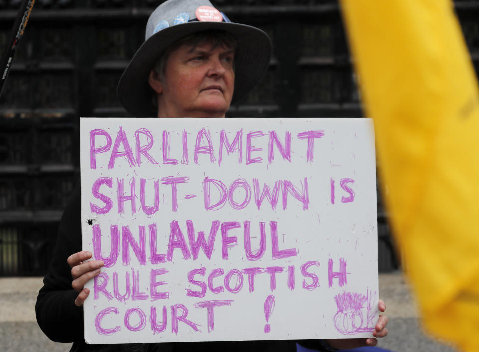 A Pro EU protestor shows a poster in front of the Houses of Parliament entrance in London, Wednesday, Sept. 11, 2019.(AP Photo/Frank Augstein)