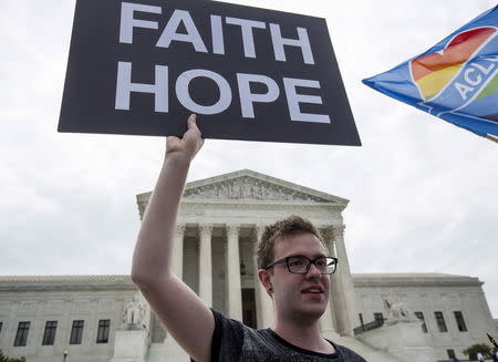 Casey Kend of New York and a supporter of gay marriage holds a sign in front of the Supreme Court, June 26, 2015. REUTERS/Joshua Roberts