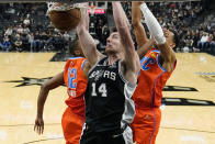 San Antonio Spurs forward Drew Eubanks (14) scores against Oklahoma City Thunder forward Mamadi Diakite (12) and forward Darius Bazley (7) during the second half of an NBA basketball game, Wednesday, Jan. 19, 2022, in San Antonio. (AP Photo/Eric Gay)