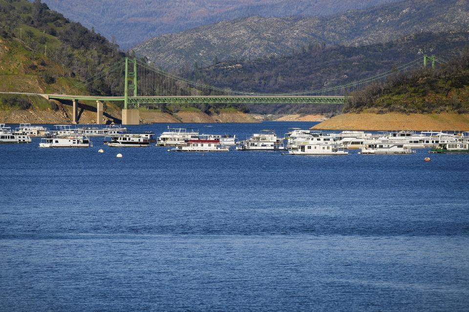 Houseboats float near Lake Oroville's Bidwell Bar Bridge at on Sunday, March 26 2023, in Butte County, Calif. Months of winter storms have replenished California's key reservoirs after three years of punishing drought. (AP Photo/Noah Berger)