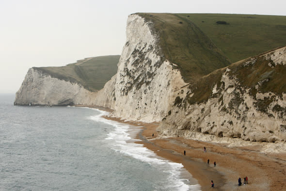 A view of the beach and cliffs at Durdle Door on Dorset's Jurassic Coast.  The half term school holiday and news of a recent significant find of the jaw bones of a pliosaur brought hunters out in their droves. The local coast is classified as a World Heritage Site and is famous for its abundance of fossils. It covers 95 miles of coastline in East Devon and Dorset, with rocks recording 185 million years of the Earth's history. World Heritage status was achieved because of the site's unique insight into the earth sciences as it clearly depicts a geological ?walk through time' spanning the Triassic, Jurassic and Cretaceous periods. Rain causes landslides allowing the cliff face to reveal the treasures beneath.