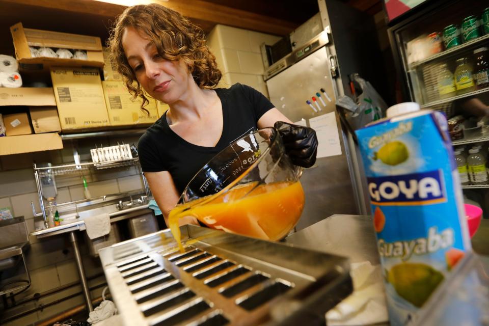 Monica Ferracioli pours the passion fruit mixture into the popsicle mold at the newly opened Sorbae Frozen Treats at Fort Taber Park in New Bedford.