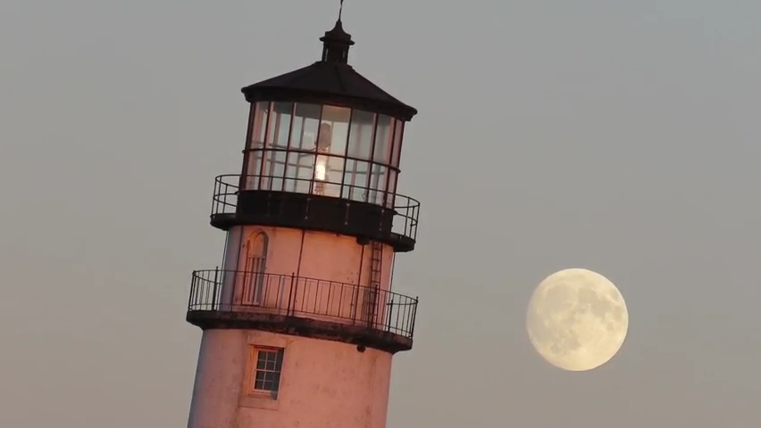 The rising Hunter's Moon dances a tango with Highland Light in Truro.