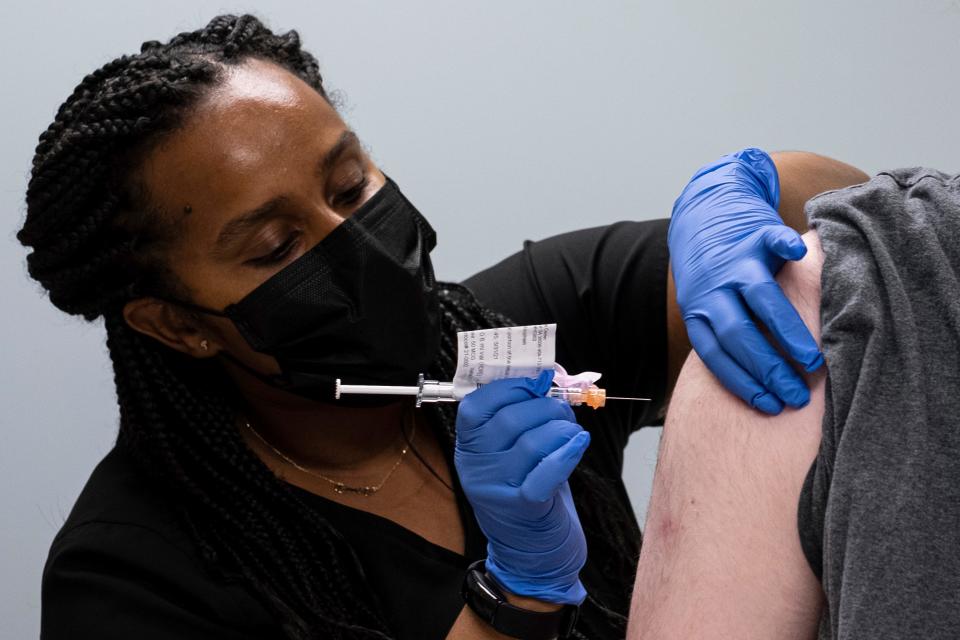 Cole Smith receives a Moderna variant vaccine shot from clinical research nurse Tigisty Girmay at Emory University's Hope Clinic in Decatur, Ga., in March 2021.
