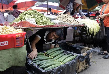 A vendor adjusts cucumbers for sale at a market in Beijing, September 9, 2013. REUTERS/Jason Lee