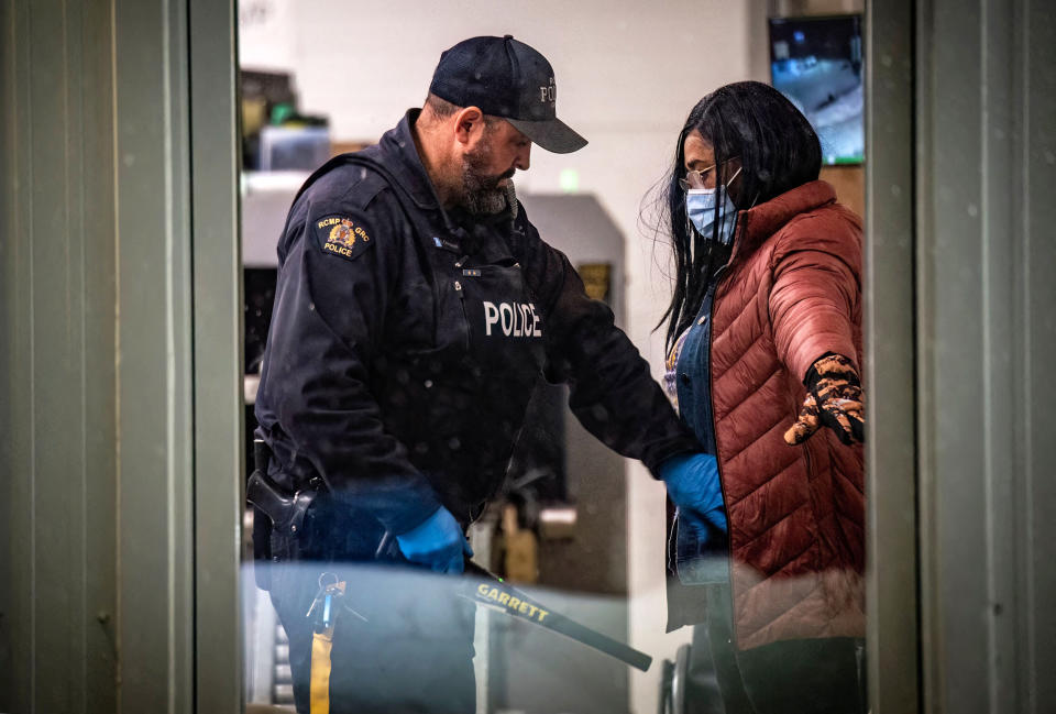 A migrant is searched by a police officer after arriving at the Roxham Road border crossing in Roxham, Quebec, Canada, on March 2, 2023. - In 2022, the number of asylum seekers who crossed into Quebec via this road exceeded 39,000, doubling a previous record from 2017. (Sebastien St-Jean / AFP - Getty Images)