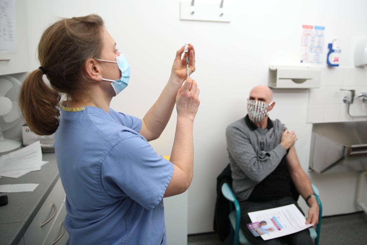 <p>Dr Jess Harvey prepares the Pfizer-BioNTech coronavirus vaccine for injection at the Northgate Health Centre in Bridgnorth</p> (PA)