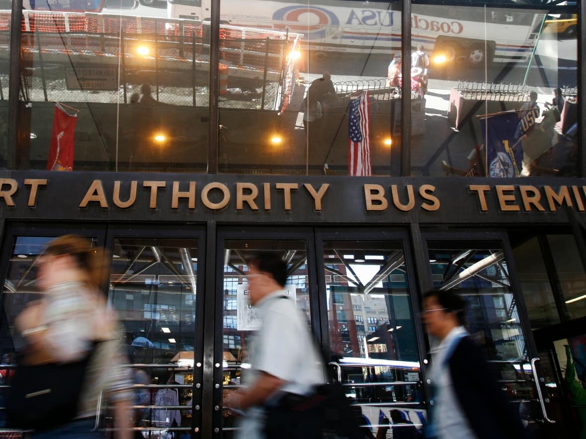 Commuters enter the Port Authority Bus Terminal in New York City. Asylum seekers have been arriving at the terminal on a regular basis, seeking assistance from National Guard officers posted there. That happened when the city declared a state of emergency last October. (Shannon Stapleton/Reuters - image credit)