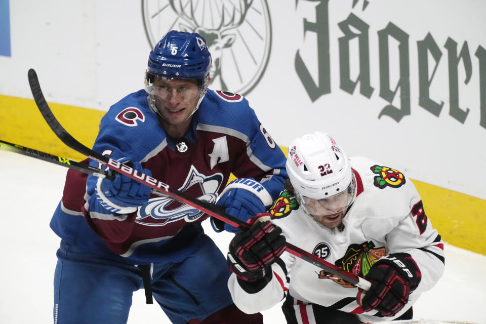 Colorado Avalanche defenseman Erik Johnson, left, checks Chicago Blackhawks center Ryan Carpenter during the third period of an NHL hockey game Wednesday, Oct. 13, 2021, in Denver. The Avalanche won 4-2. (AP Photo/David Zalubowski)