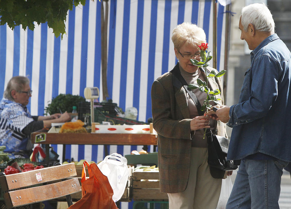 In this picture taken Sept. 5, 2013 a man offers a rose to a woman in the capital city’s trendy Savior Square in Warsaw, Poland. It has become one of the capital city’s trendiest places after political and economic reform and attracts tourists, students and professionals with its numerous cafes and leisurely ambiance. (AP Photo/Czarek Sokolowski)