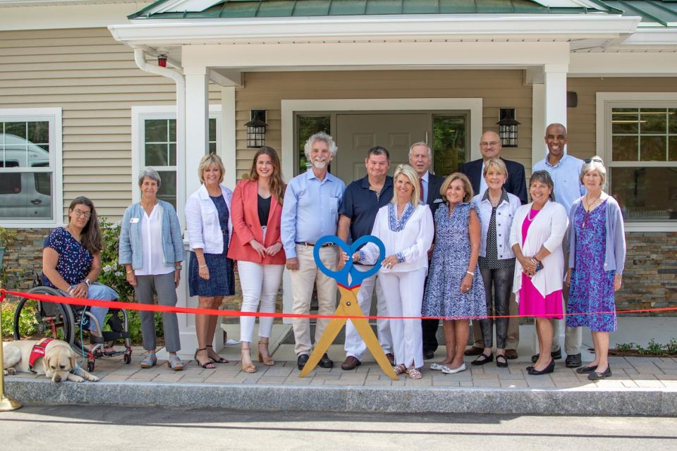 The ribbon is cut to open NEADS new breeding center. Show are (from left) NEADS service dog Jones; NEADS client Katelynne Steinke; NEADS Board member Sue Feit; state Rep. Kimberly Ferguson; state Rep. Meghan Kilcoyne; NEADS Board Vice Chair A. Kim Saal; donors Larry and Nanine Costa; NEADS CEO Gerry DeRoche; co-chair of NEADS Foundations for the Future Capital Campaign Committee Cindy Lepofsky; NEADS Board member James Hicks; former MA Attorney General Martha Coakley; state Sen. Anne Gobi; NEADS Board chair Geoff Worrell; and NEADS Board member Carol Krauss.