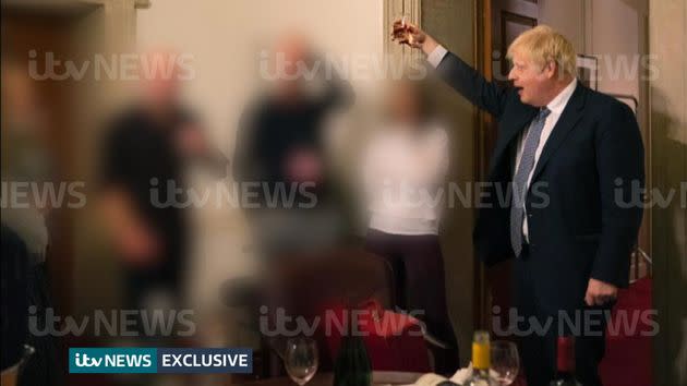 A photograph obtained by ITV News of the prime minister raising a glass at a leaving party on November 13, 2020, with bottles of alcohol and party food on the table in front of him. (Photo: ITV/PA)