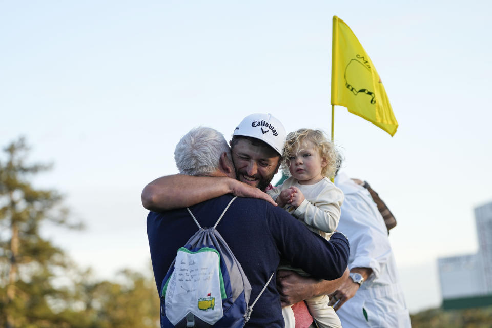 Jon Rahm, of Spain, celebrates his Masters win with his father Edorta Rahm and son Kepa after winning the Masters golf tournament at Augusta National Golf Club on Sunday, April 9, 2023, in Augusta, Ga. (AP Photo/David J. Phillip)