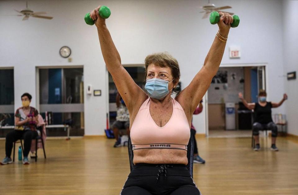 Elma Hamblet Bastien, center, lift her arms while working with weights during the Medicare Advantage program that offers up Silver Sneakers fitness classes on Tuesday, October 20, 2020 at the Alper Jewish Community Center in Kendall, Florida.