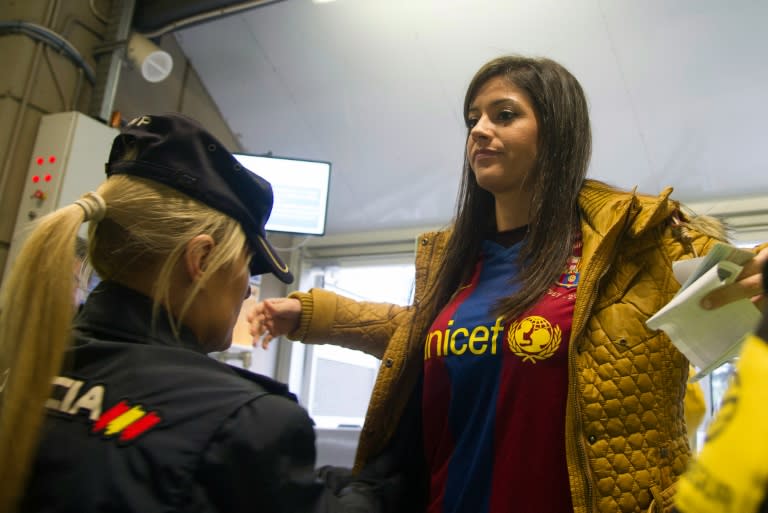 A Spanish policewoman searches a spectator before the Spanish league "Clasico" football match Real Madrid CF vs FC Barcelona at the Santiago Bernabeu stadium in Madrid on November 21, 2015