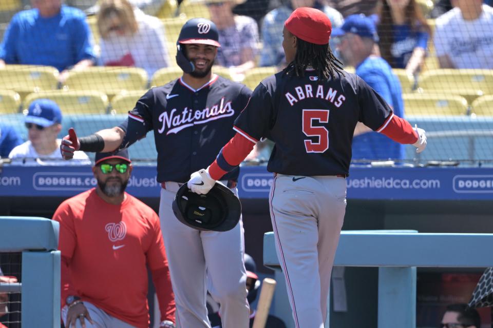 Washington Nationals shortstop CJ Abrams (5) is greeted at the dugout by second baseman Luis García Jr. (2) after Garcia hits a home run against the Los Angeles Dodgers on April 17, 2024.