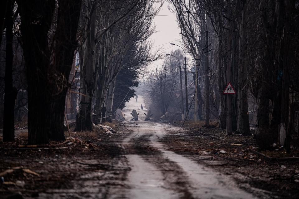 Local residents walk down a street as the sounds of shelling continue  in Bakhmut (AFP via Getty Images)