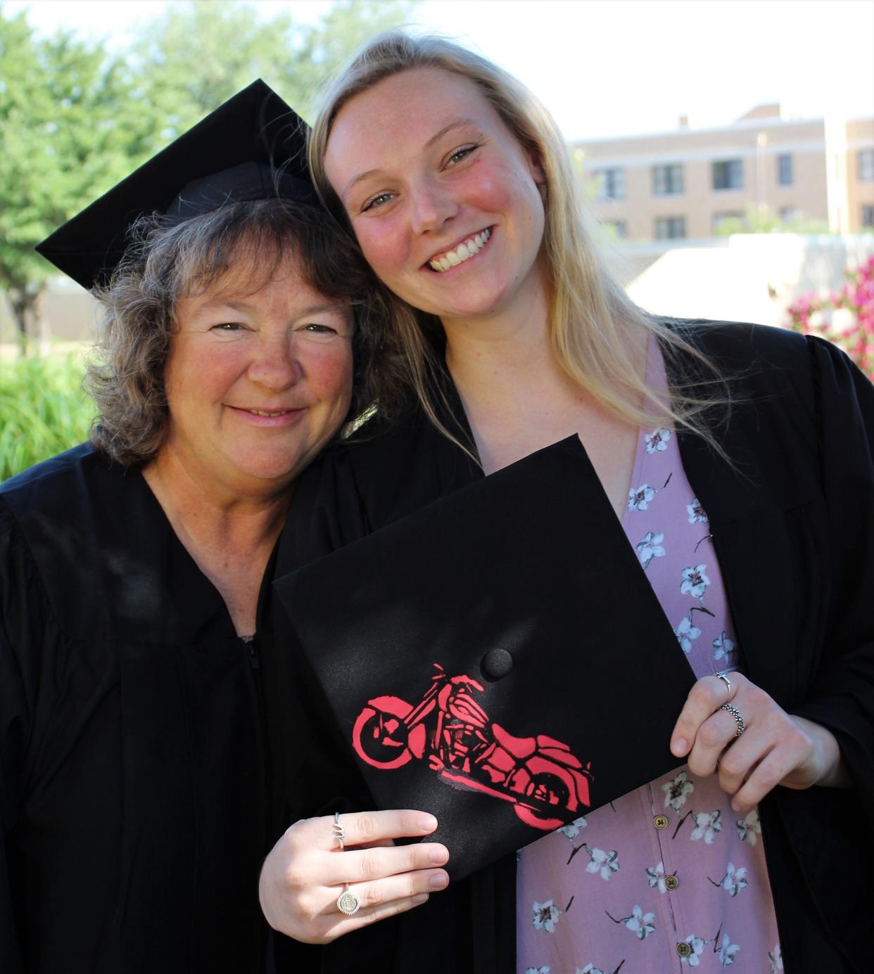 Melinda Roberson, left, with her daughter, Mandy on the McMurry University campus. They graduate together Saturday, both with degrees in accounting. Mom had to take 79 hours the past 18 months to catch up to Mandy, who is holding her mortar board with an image of a motorcycle that she painted. It honors Raymond "Pops" Roberson, her grandfather, who died last May.
