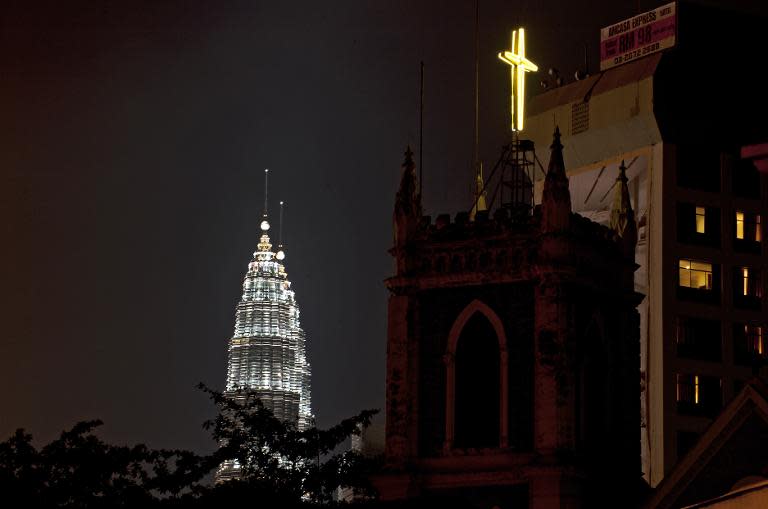 A Christian cross is seen on the top of a church next to Malaysia's iconic Petronas Towers, in central Kuala Lumpur, in 2011