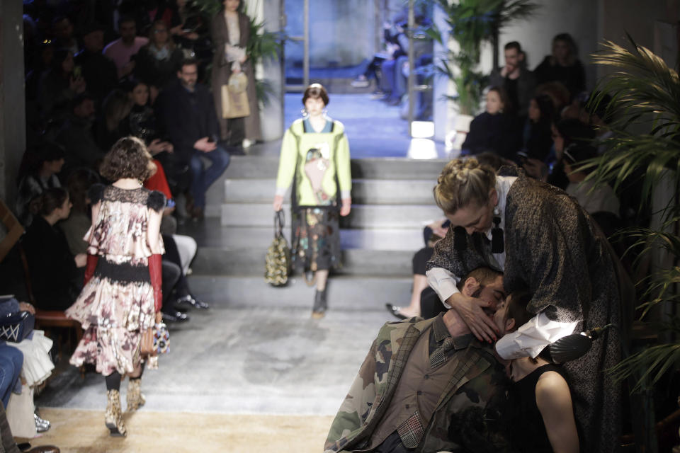 Models wear creations as actors perform, at right, part of the Antonio Marras women's Fall-Winter 2019-2020 collection, that was presented in Milan, Italy, Sunday, Feb.24, 2019. (AP Photo/Luca Bruno)