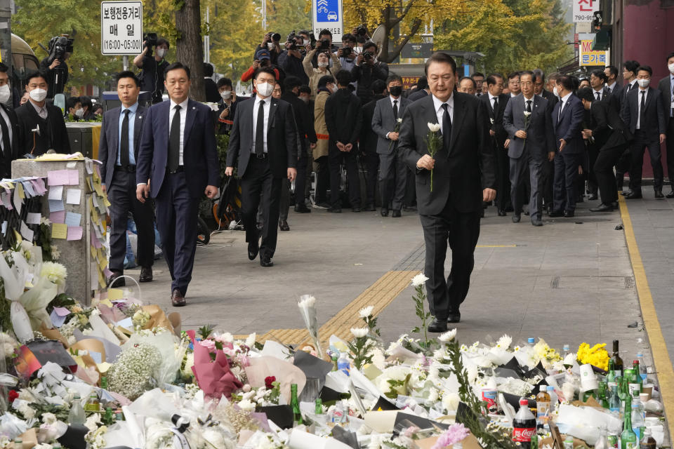 South Korean President Yoon Suk Yeol, right, arrives to pay tribute to victims of a deadly accident following Saturday night's Halloween festivities on a street near the scene in Seoul, South Korea, Tuesday, Nov. 1, 2022. (AP Photo/Ahn Young-joon)