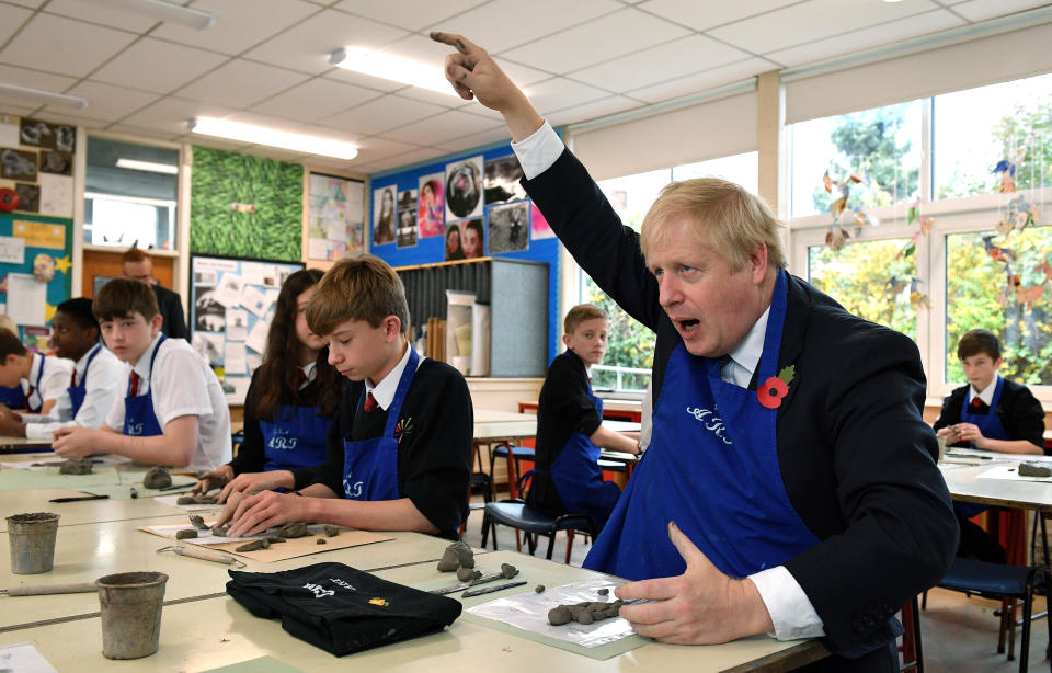 Britain's Prime Minister Boris Johnson reacts as he participates in a school art lesson to make a clay figure, at the George Spencer Academy school in Nottingham, England, during a general election campaign visit Friday Nov. 8, 2019. Britain goes to the polls on Dec. 12 to vote in a pre-Christmas general election. (Daniel Leal-Olivas/Pool via AP)