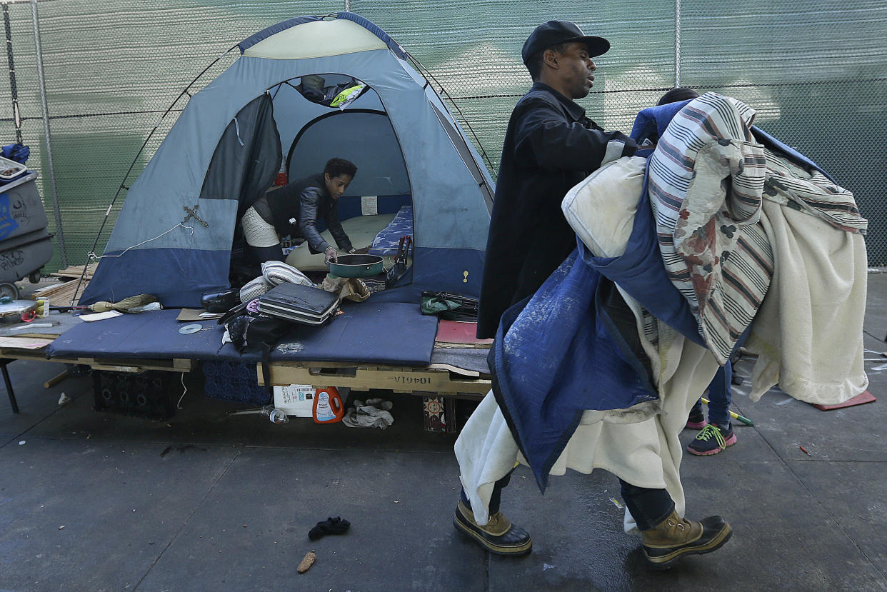 A homeless couple gather their belongings at a tent camp in San Francisco. Half the money that the newly passed Proposition C generates will go toward building permanent housing for homeless&nbsp;residents. (Photo: ASSOCIATED PRESS)