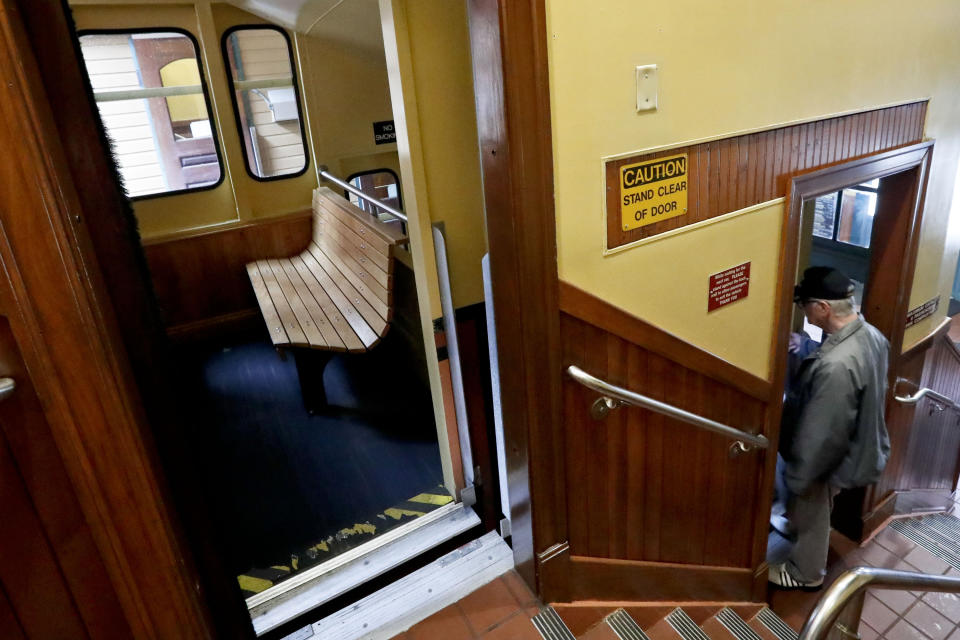 A patron boards one of the cars of the Monongahela Incline on Friday, May 10, 2019, in Pittsburgh. The incline that transports people up and down the side of a hill in Pittsburgh reopened Friday after being closed since February. (AP Photo/Keith Srakocic)