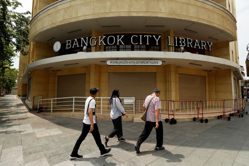 People walk past the closed city library as the country struggles with a third wave of infections of the coronavirus disease outbreak in Bangkok