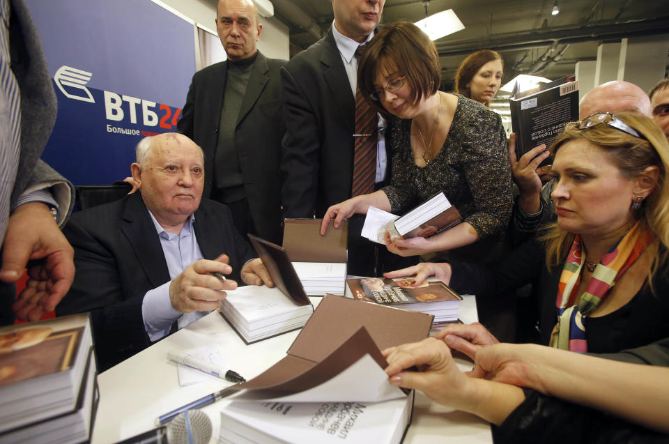 Former Soviet leader Mikhail Gorbachev, left, signs his book in a book shop in Moscow, Russia, Tuesday, Nov. 13, 2012. Mikhail Gorbachev looks back at his life in his new book Alone with Myself. He talks about his young years with a remarkable candor in the book, which is full of love for his late wife. (AP Photo/Misha Japaridze)