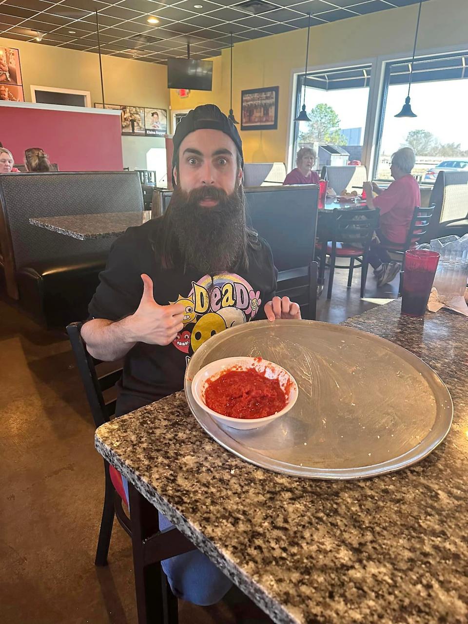 Competitive eater and YouTube star Adam Moran from England is pictured Jan. 4 after successfuly completing the calzone challenge at Tre Ragazzi's Glencoe location. It involves eating the restaurant's super-sized calzone with at least three toppings, including two meats, within an hour. 
