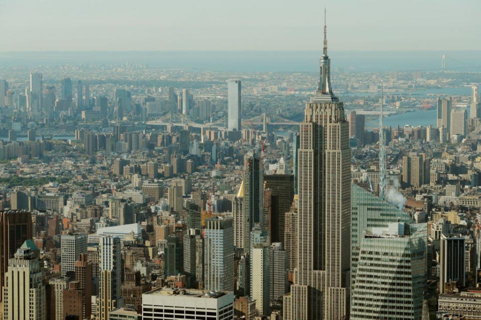 The Empire State Building rises above Manhattan in front of the Brooklyn and Manhattan bridges as seen from an apartment in the Central Park Tower building as the building celebrates its topping out in New York (Reuters)